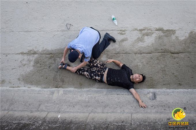 男子示意要喝水，民警拿起旁边的矿泉水给他喂水，让他慢慢喝，男子示意腰痛。